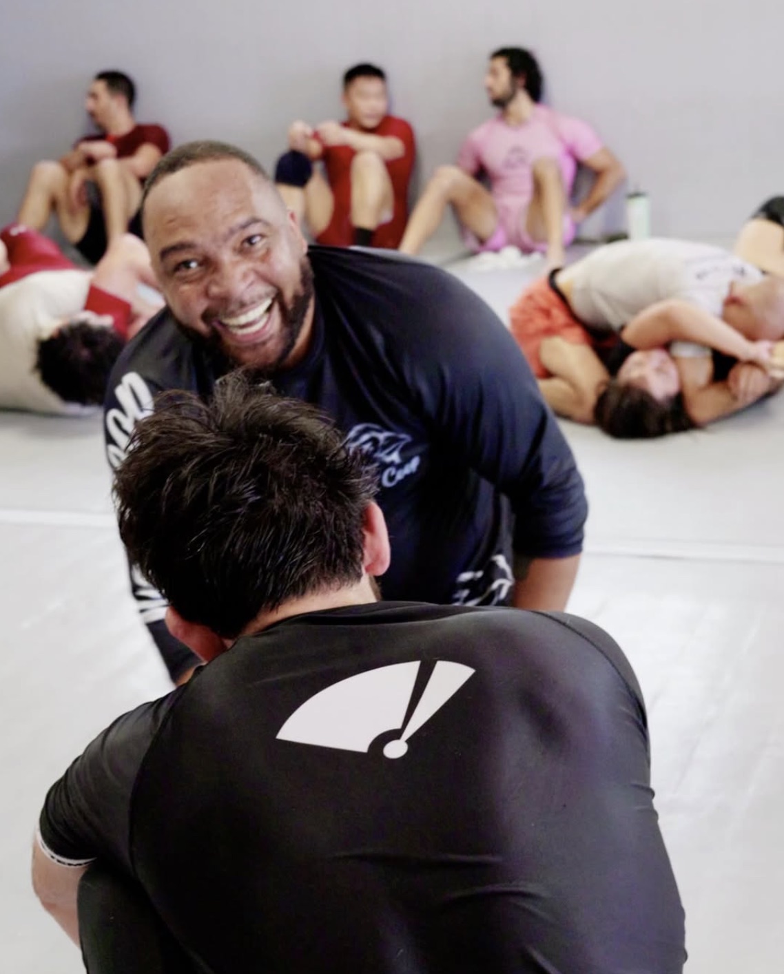 A Coop black belt laughing mid-class on the mats